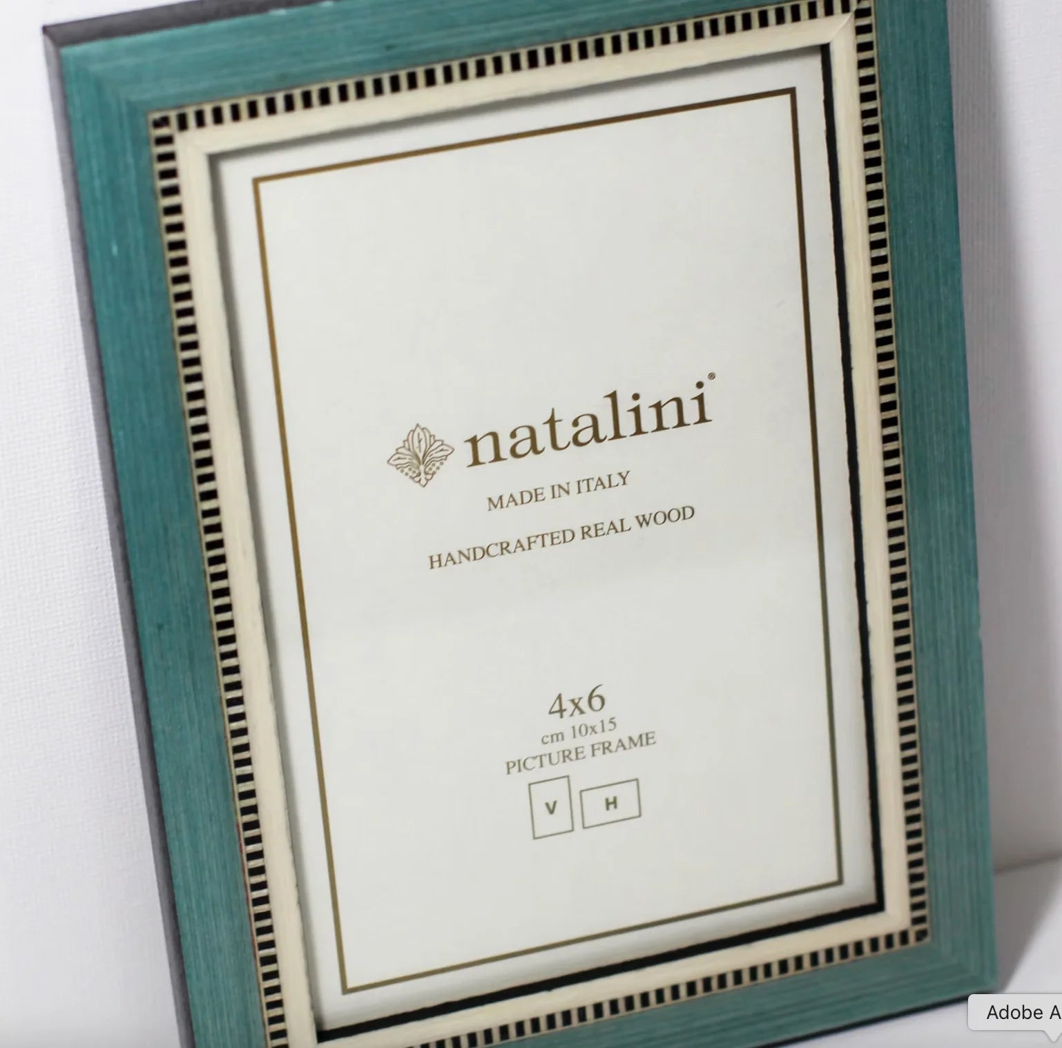 Teal picture frame with 'natalini' branding on a white background