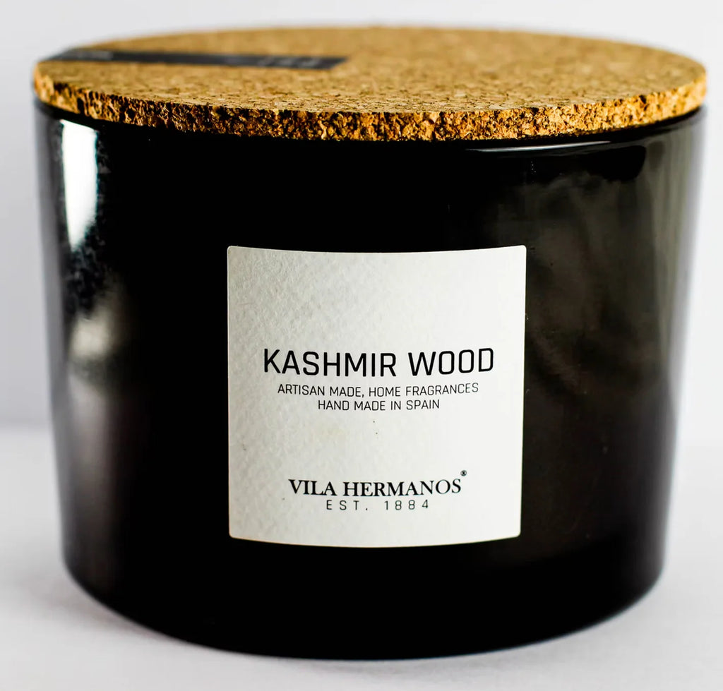Black candle with cork lid and 'Kashmir Wood' label on a white background