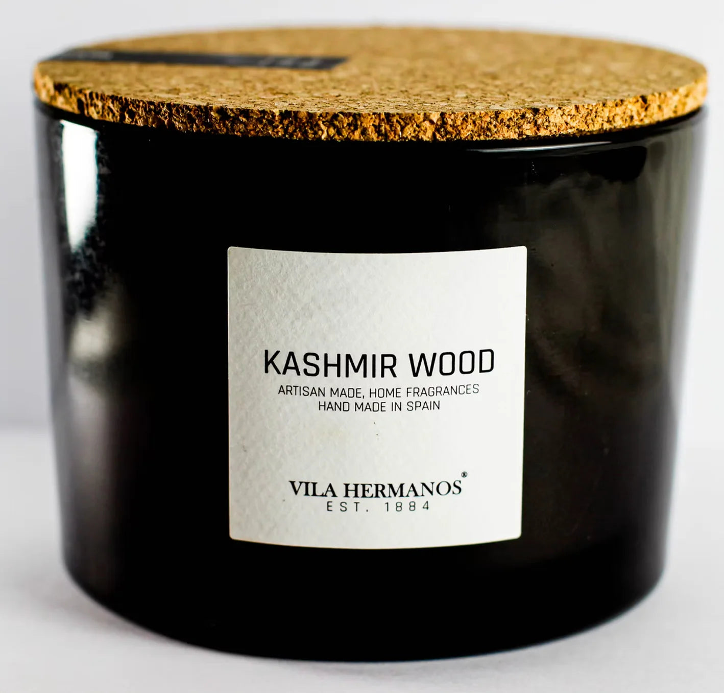 Black candle with cork lid and 'Kashmir Wood' label on a white background